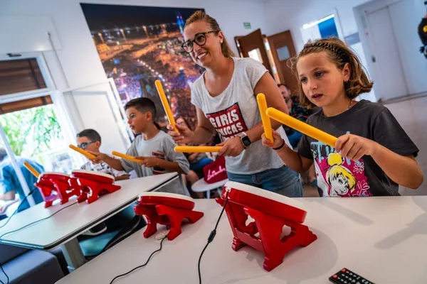 Niños y una madre tocan tambores en un videojuego de ritmo